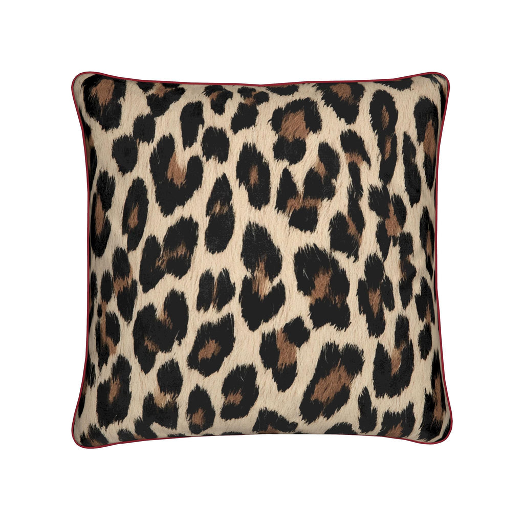 A square throw pillow featuring a classic leopard print pattern in black, brown, and beige, finished with a contrasting dark red piped border, shown against a plain white background.